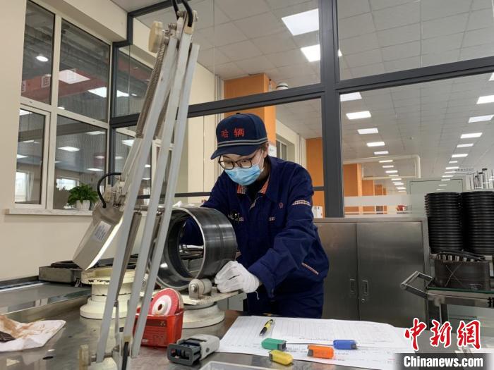 图为杨鑫淼对轴承外圈滚道面进行外观检查。 何旭 摄 图为杨鑫淼对轴承外圈滚道面进行外观检查。 何旭 摄