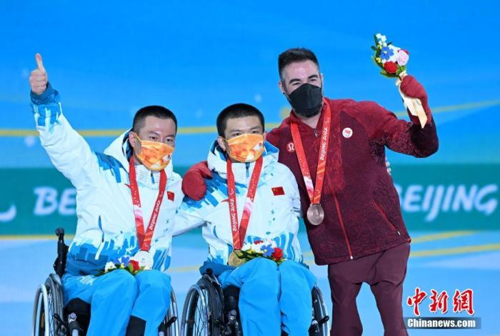 3月6日晚间,北京2022年冬残奥会残奥越野滑雪男子长距离-坐姿项目颁奖仪式在张家口颁奖广场举行,图为获得金牌的中国选手郑鹏(中)、获得银牌的中国选手毛忠武(左)和获得铜牌的加拿大选手科林·卡梅龙。 <a target='_blank' data-cke-saved-href='/' href='/'>中新社</a>记者 侯宇 摄 点击进入下一页