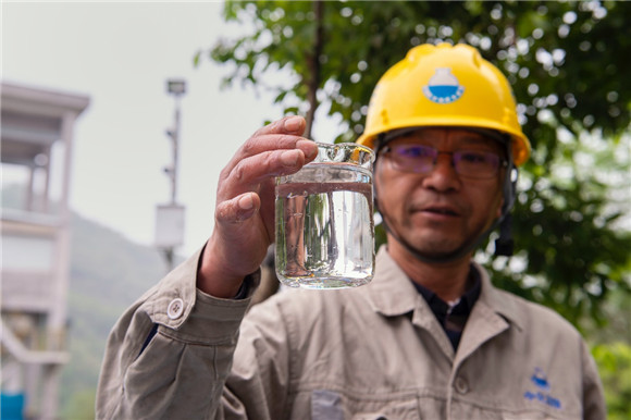 中化涪陵磷石膏渣场渗滤液处理站负责人介绍污水排放口的污水。实习生 童炳婷 摄