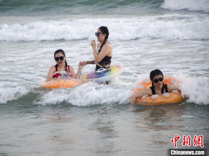 4月25日，游客在银滩冲浪。　翟李强 摄