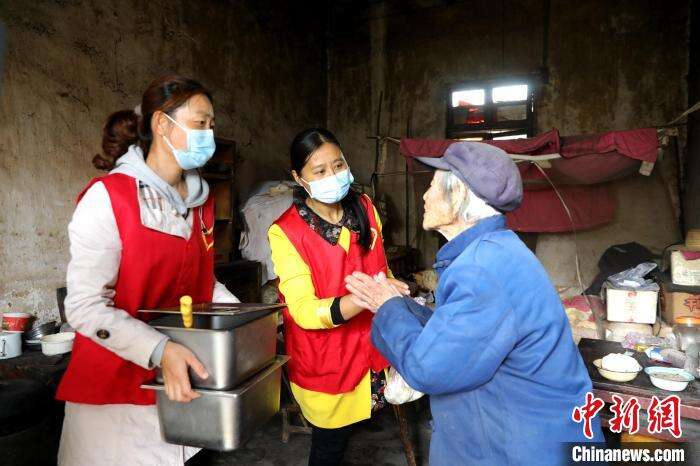 方丹(中)和志愿者上门为行动不便的老人送餐 李勤 摄