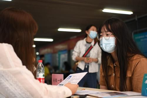 5月17日，在合肥学院内，求职者（右）向用人单位工作人员了解招聘信息。新华社记者 张端 摄