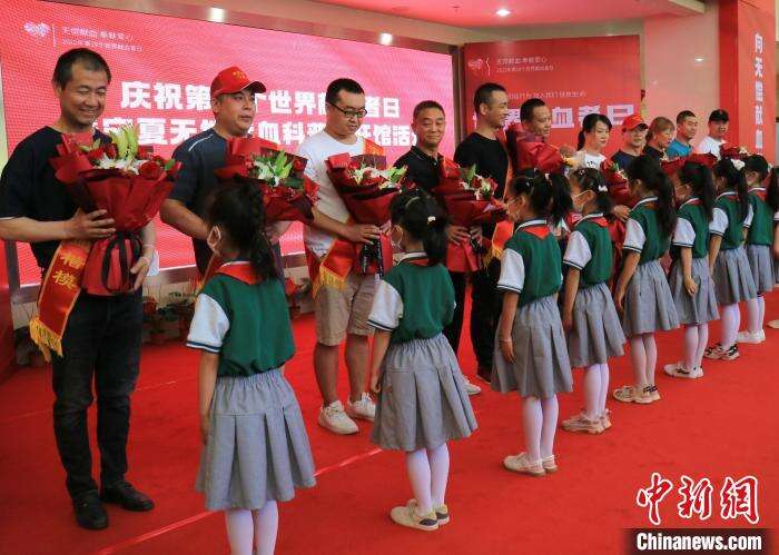 小朋友为宁夏献血百次以上楷模代表献花。　杨迪 摄